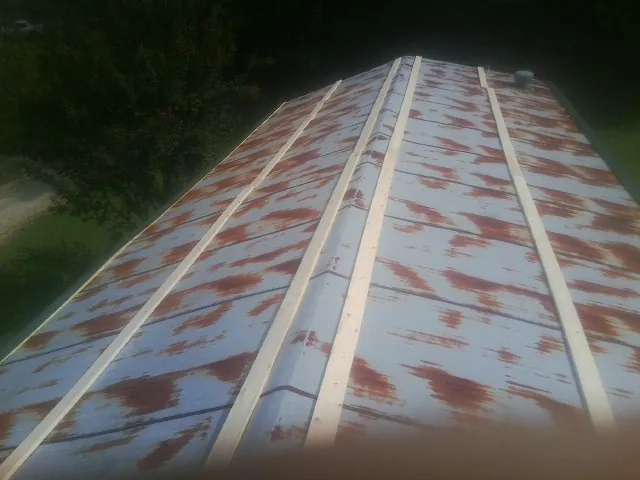 Rusted metal roof panels with new wood purlins before replacement — Storm Damage Roof Repair in Humarock by Roofing Brothers