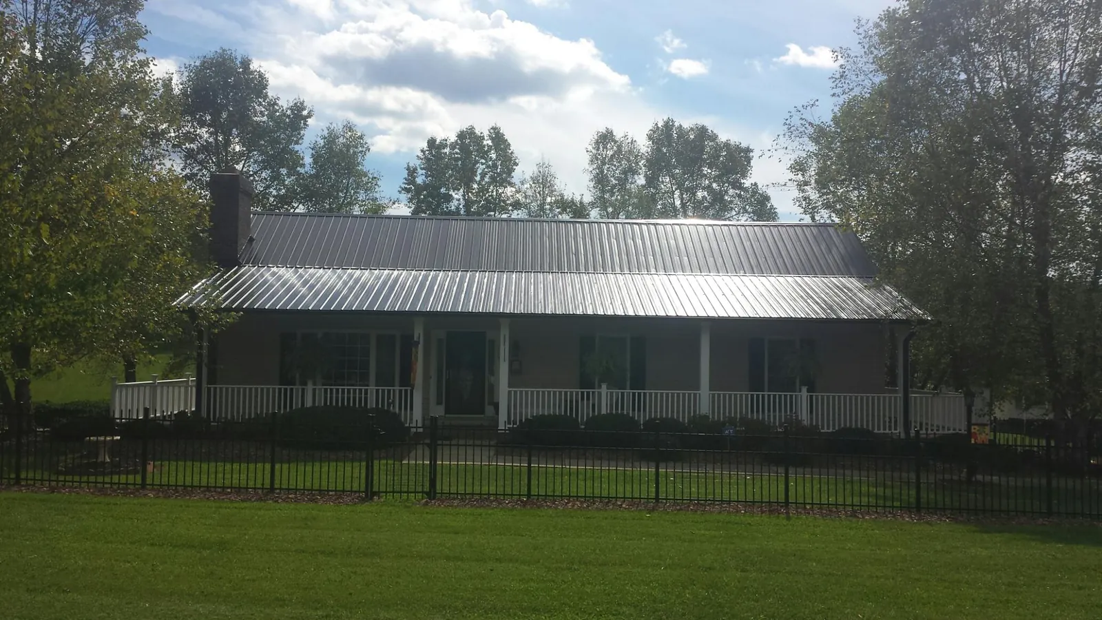 Gray metal roof on a brick ranch with a full width front porch — Gutter Guard Installation work by our crew in Humarock